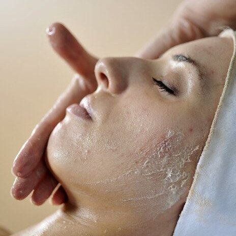 A woman getting her face washed with a hand.